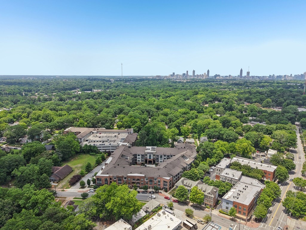 A bird's eye view of The Kirkwood Apartmenrs and the city with a large green area in the foreground.